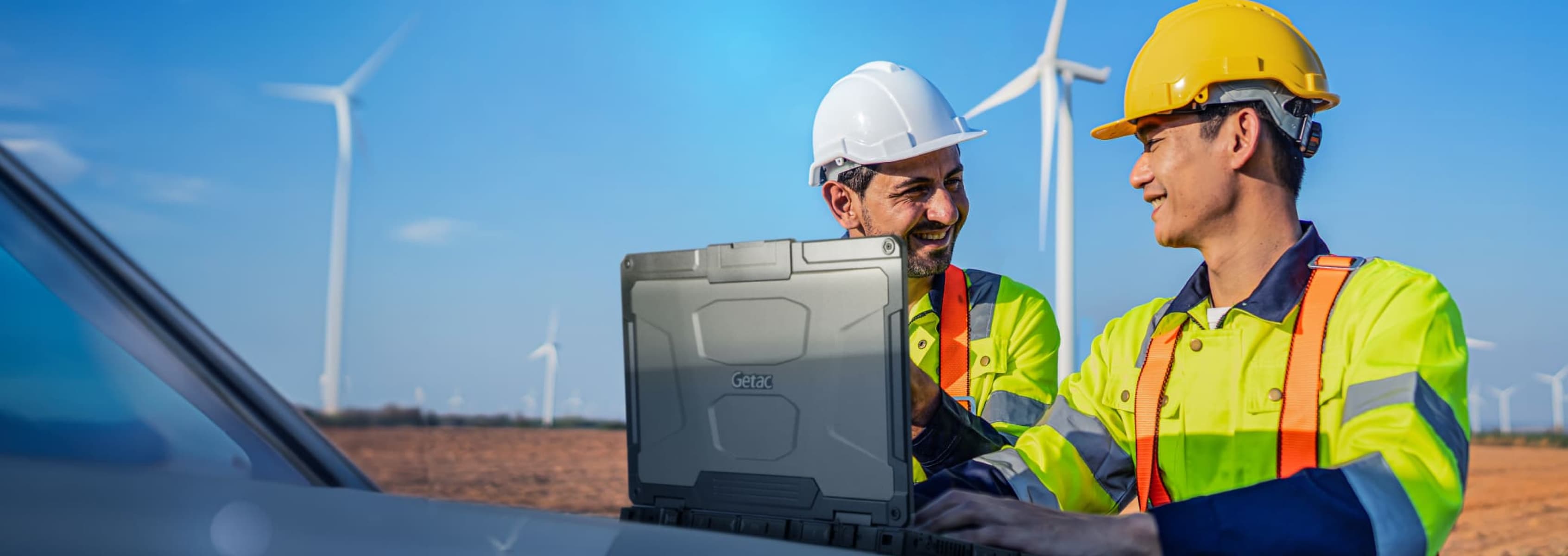 Laptop industrial robusta marca Advantech en un parque eólico con dos ingenieros trabajando